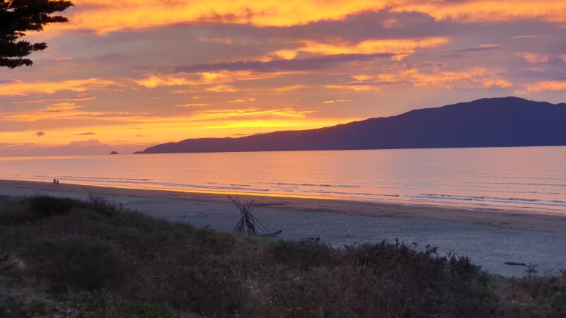 Sunset at Waikanae Beach.  That's Kāpiti Island in front of you.  Look just behind it, and you may be able to make out the South Island in the distance.